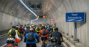 Duża grupa rowerzystów przejeżdża przez Tunel Świnoujście podczas 15. Rajdu Rowerowego Dookoła Zalewu Szczecińskiego – kolorowa kolumna uczestników w kaskach i kurtkach, zabezpieczona przez służby miejskie.