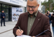Wizualizacja nowoczesnego budynku nowej Komendy Miejskiej Policji w Świnoujściu z widocznym parkingiem i zielenią.
