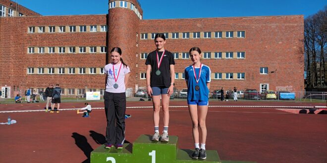 Natalia Smolińska i Helena Grudzień, lekkoatletki klubu OSiR Wyspiarz, uśmiechnięte na stadionie lekkoatletycznym.