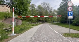 Bramownica przy parkingu miejskim z oznaczeniem ograniczenia wysokości
