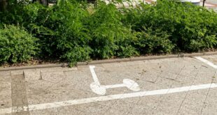Wyznaczone linie i znak pionowy określające miejsce do parkowania hulajnóg elektrycznych na chodniku w Świnoujściu.